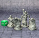 a group of silver figurines sitting on top of a tile floor